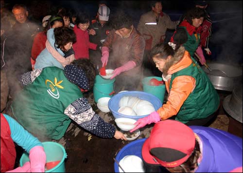 봉화산 일출제에 참석한 관광객들에게 떡국을 나누어주고 있다. 